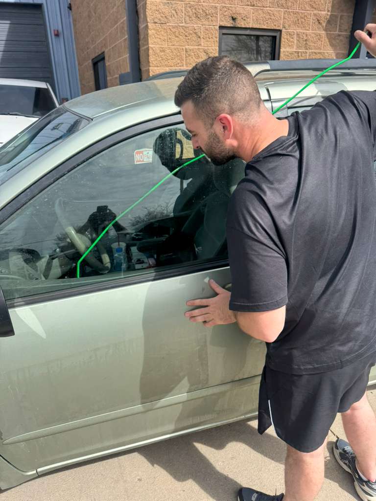Elite Locksmiths Denver technician using an inflatable air shim to open a locked car