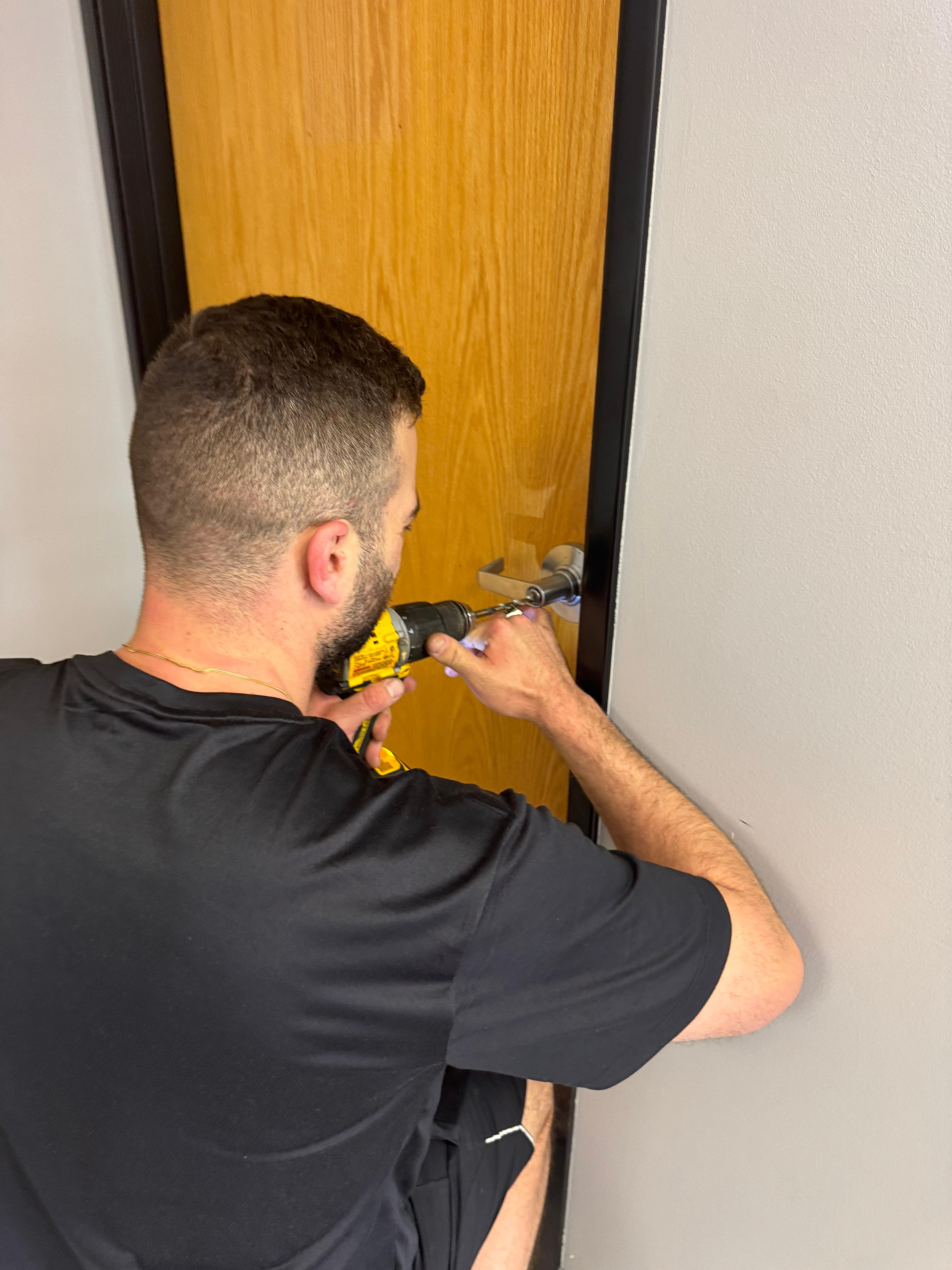 Elite Locksmiths Denver technician drilling and installing a new deadbolt lock